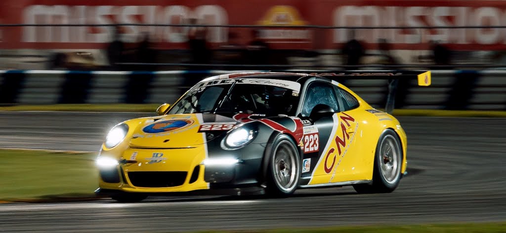 A CMN Racing car flying through a nighttime race